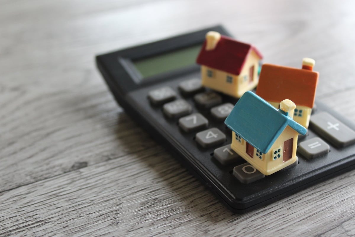 A toy house beside a calculator representing affordable homeownership and planning